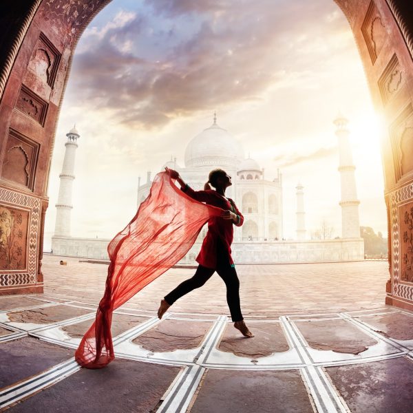 Woman with red scarf dancing near Taj Mahal in Agra, Uttar Pradesh, India